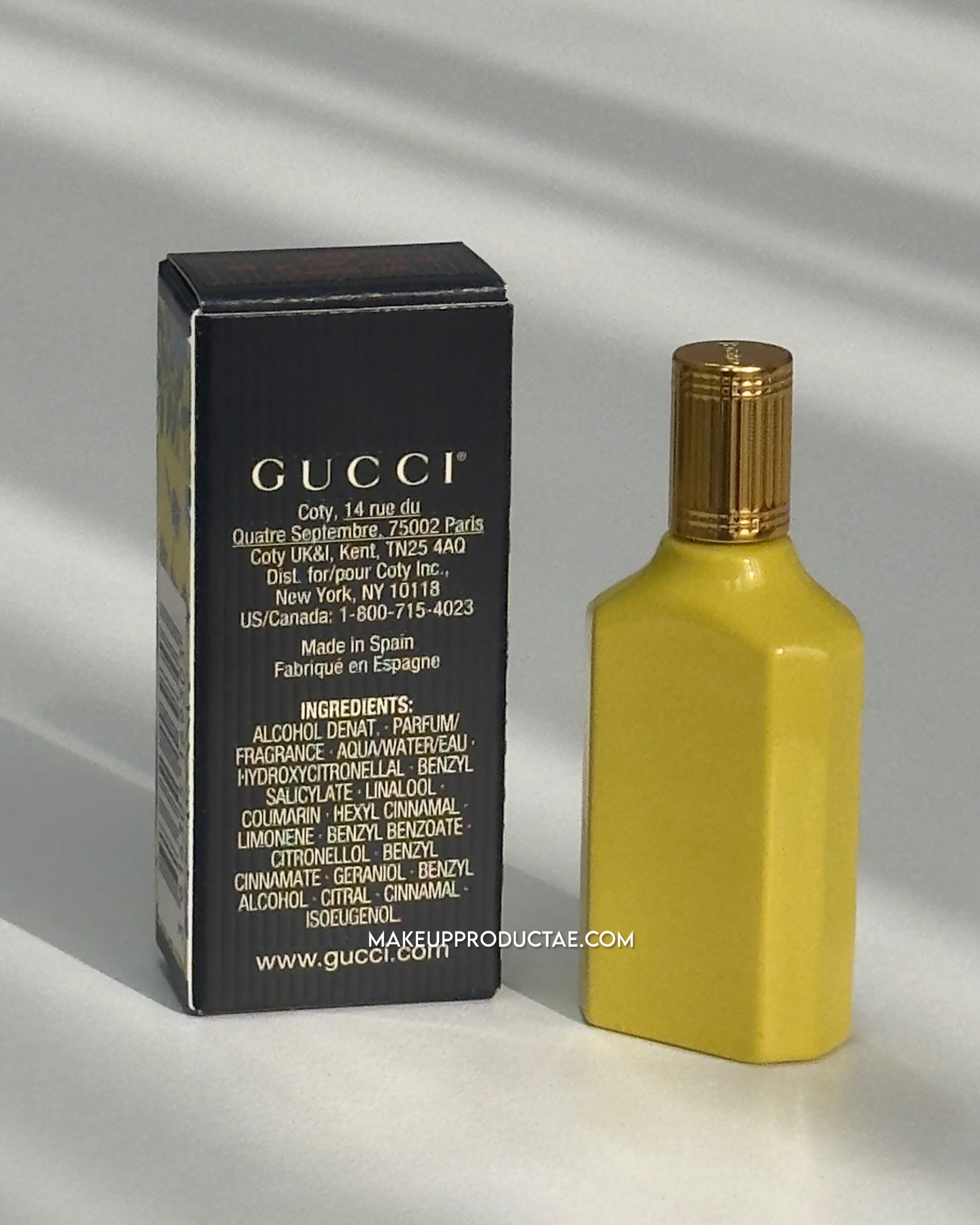 Yellow Gucci perfume bottle with packaging on a light gray background