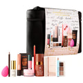 Sephora Makeup Favorites Kit containing multiple cosmetic products arranged in front of a black zippered carrying case with a printed product card. Visible items include a pink makeup sponge, brown pencil, gold-capped cream bottle, pink cream jar, brown powder compact, dual-color eyeshadow palette, and other makeup items on a white background.