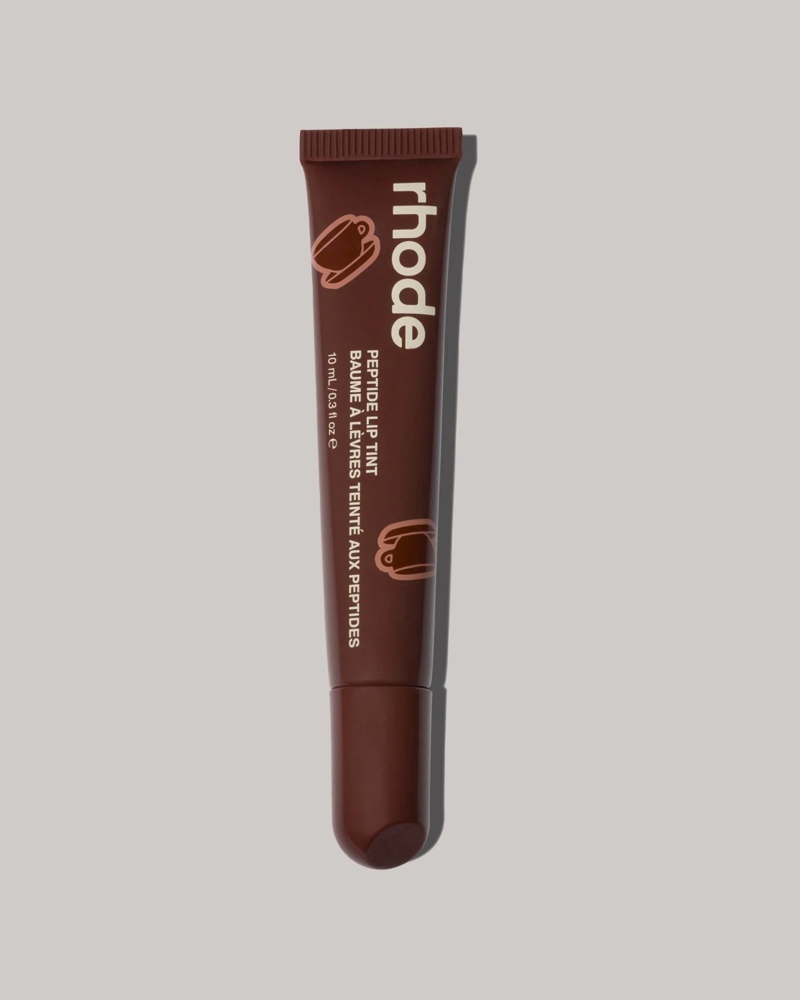 Brown lip balm tube with 'rhode' branding on a gray background